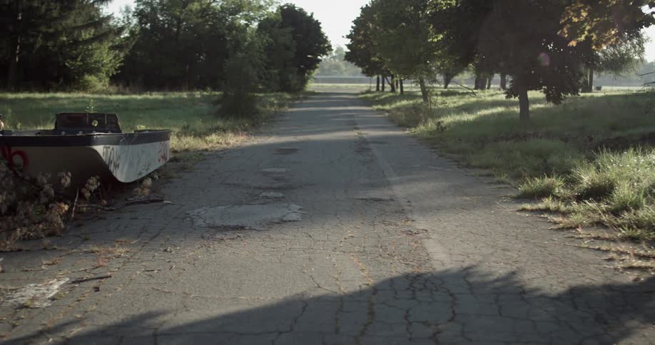 A dilapidated boat sits on the side of a road
