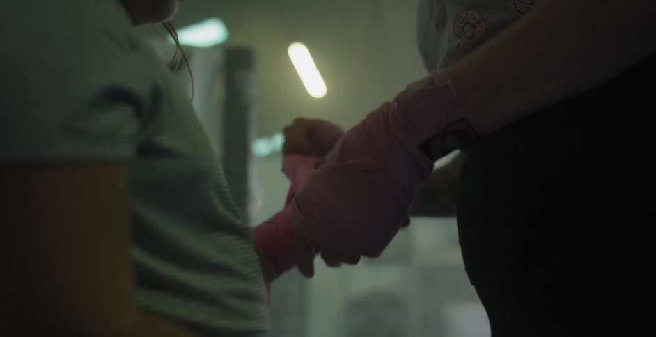 A woman's hand is wrapped in pink tape