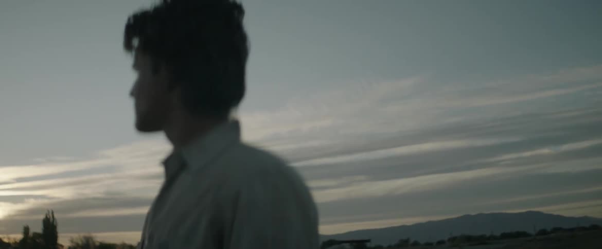 A man stands outside at dusk