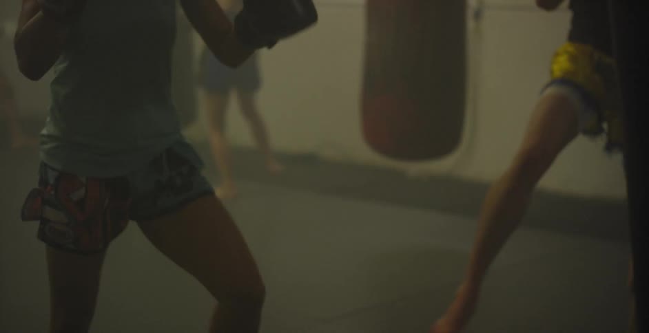 Women practice sparring in a gym