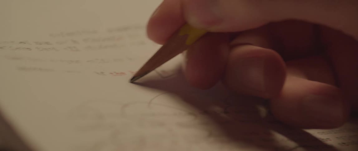 A person edits a paper with a pencil