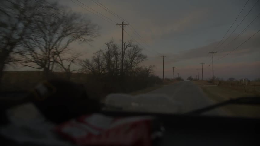 A vehicle travels down a rural road