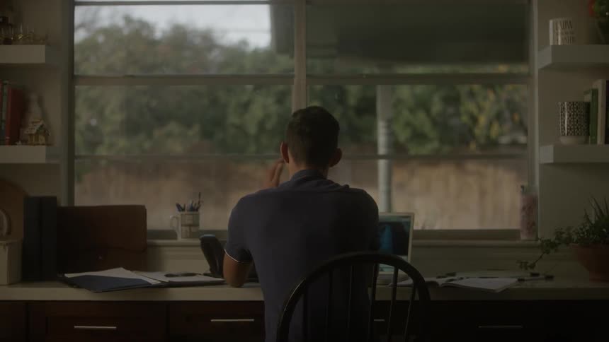 A man is sitting at his desk working
