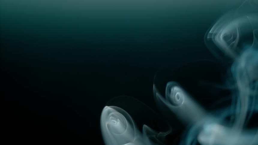 Smoke swirls slowly floating in a dark area