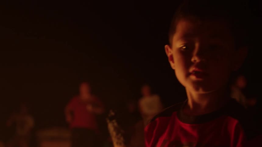 A couple of kids are toasting marshmallows on a stick