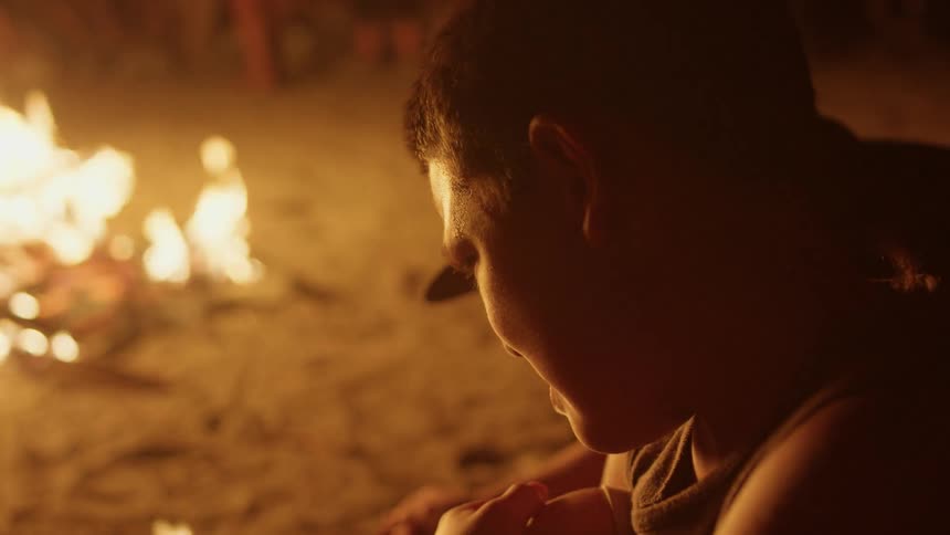 People roast marshmallows over an open fire