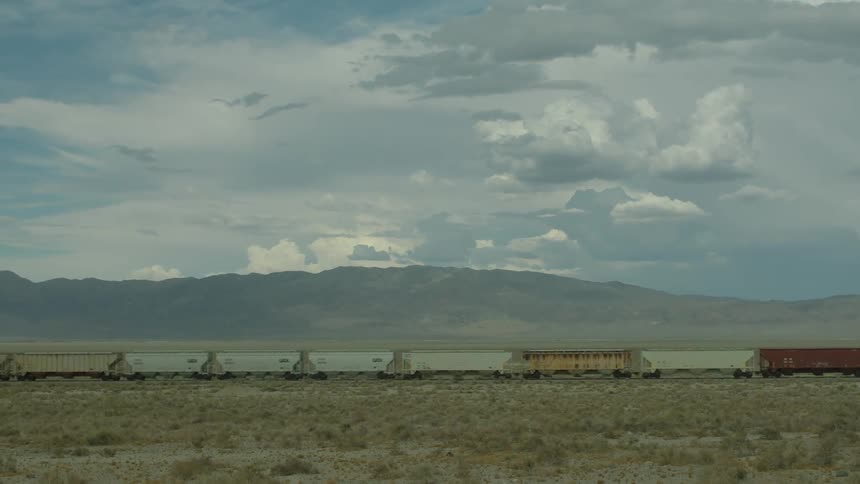 A train travels on tracks in a large field