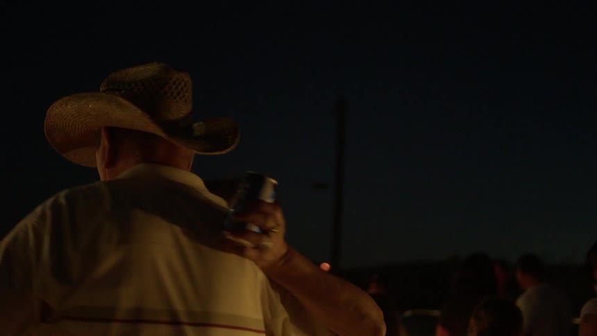 An elderly couple dance outside at night
