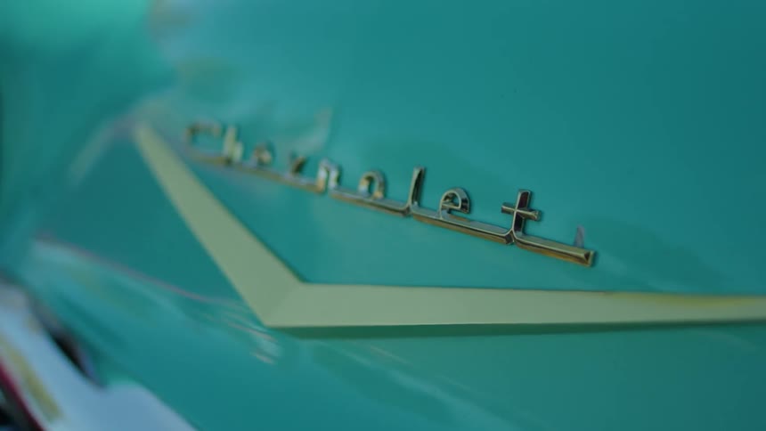 A classic blue car is filmed close up on the trunk