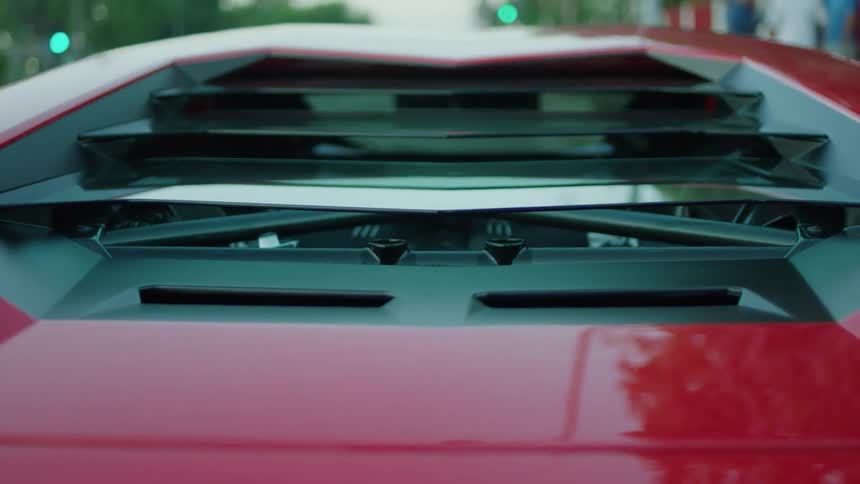 A red sports car sits parked on the side of the road