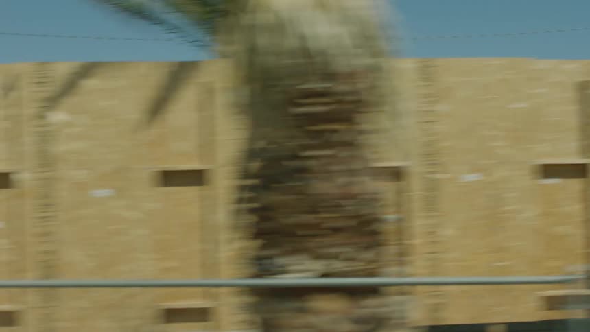 The houses and cars are surrounded by sand and desert