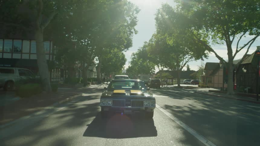 Vehicles travel down a town road