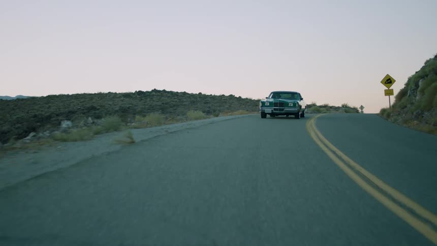A vehicle rides down a mountain road