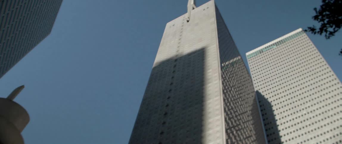 A large building is filmed from the street level looking up