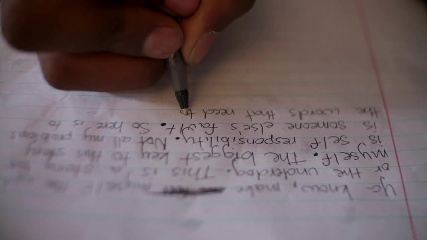 A person writes in a notebook