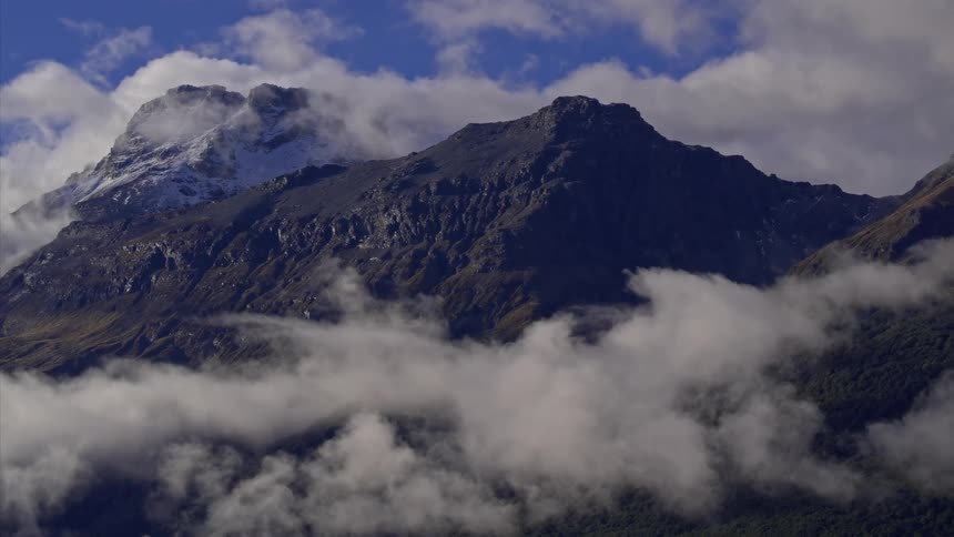 Clouds pass through tall mountains