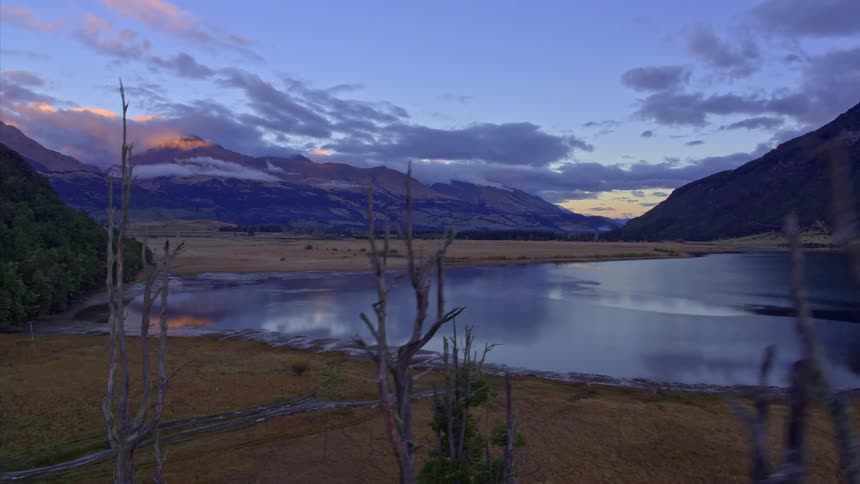 A sunset reflects on a mountain lake