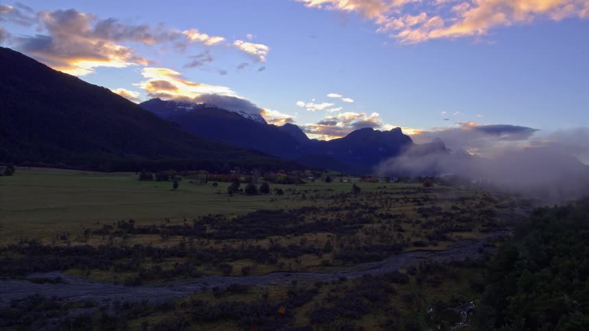 The sun sets over a mountain valley