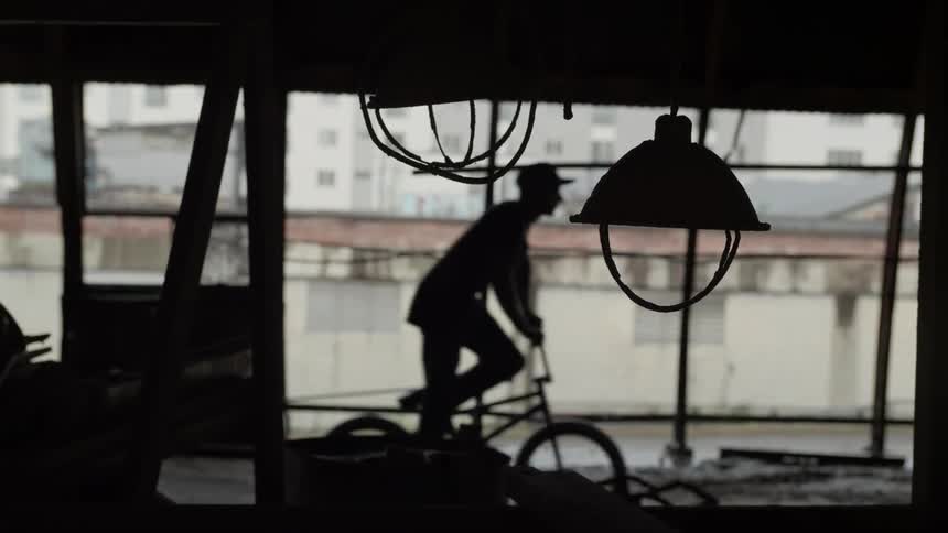 Man rides bicycle in warehouse