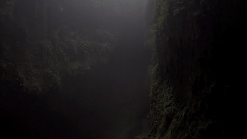 A dark foggy cave is filmed