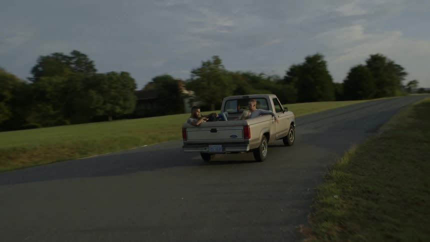 People ride in the back of a pickup truck