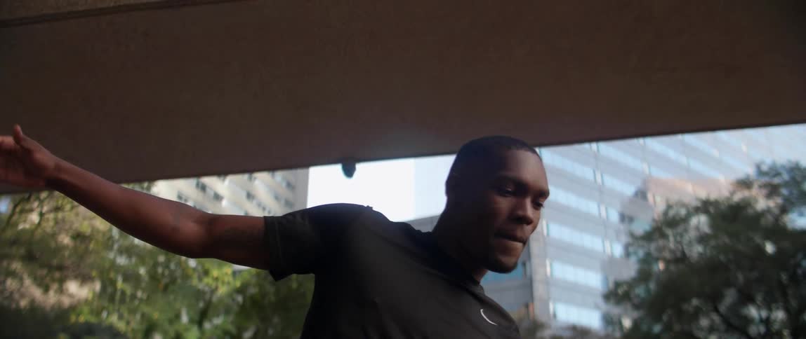 A black man jumps and balances outside