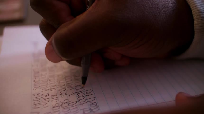 A person writes in a notebook