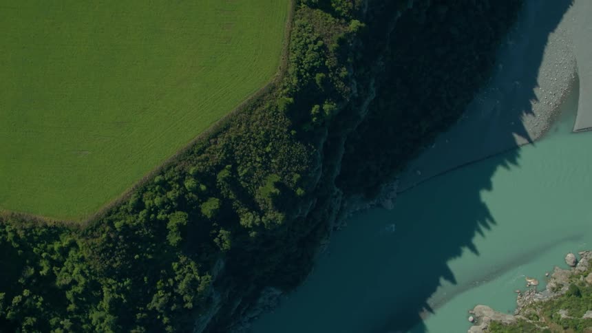Trees form a shadow on a blue water river