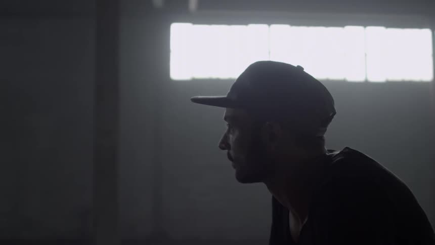 A man rides through a dim concrete room