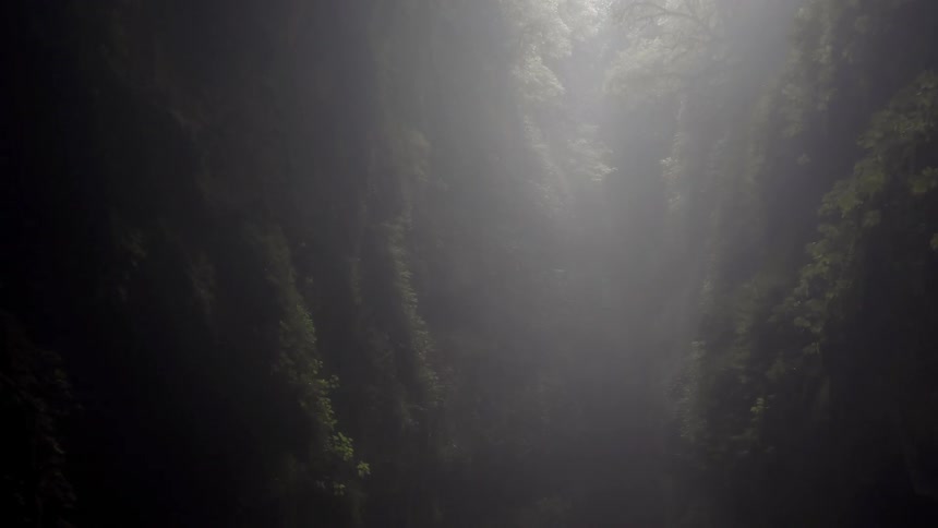 The sun shines down into a cavern