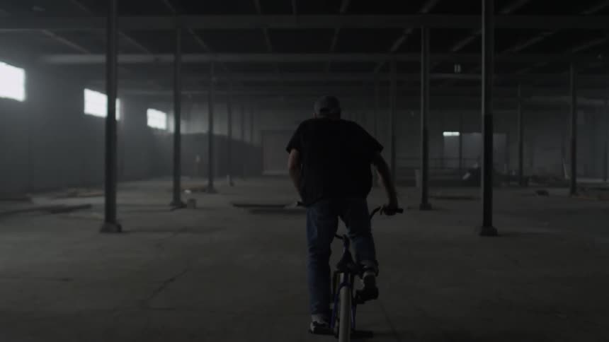 A man riding a bike through a warehouse