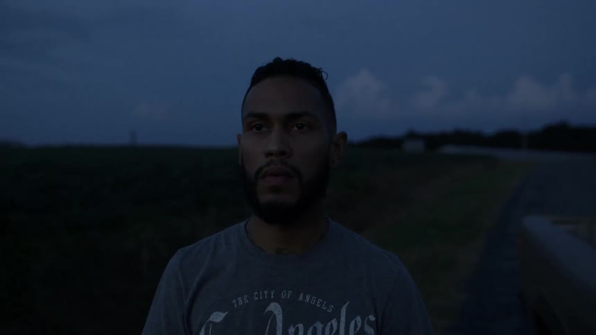 A man smokes a cigarette outside at night