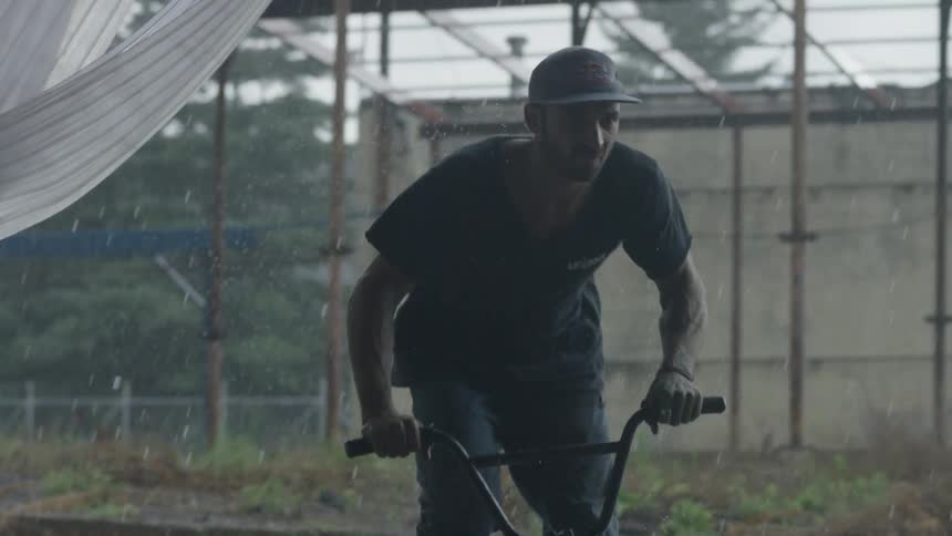 A man rides his bicycle through the rain