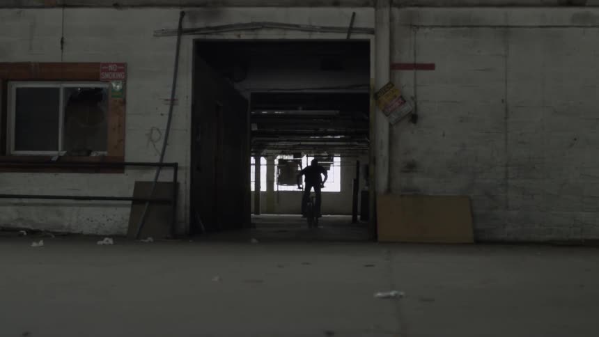 A man rides a bike into a building