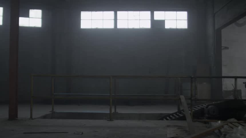 The warehouse is empty with some light shining in the window