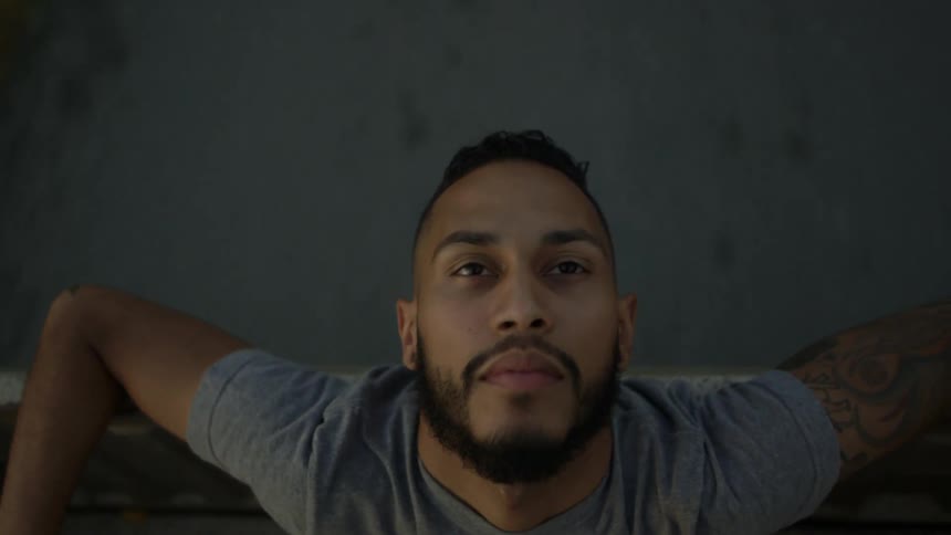 A man is leaning back riding in a vehicle looking up