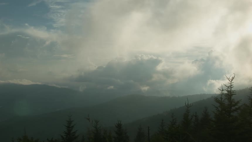 Clouds moving slowly over hilly landscape