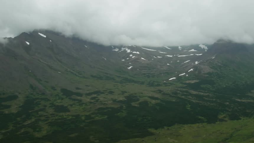 Clouds hang over mountain peaks
