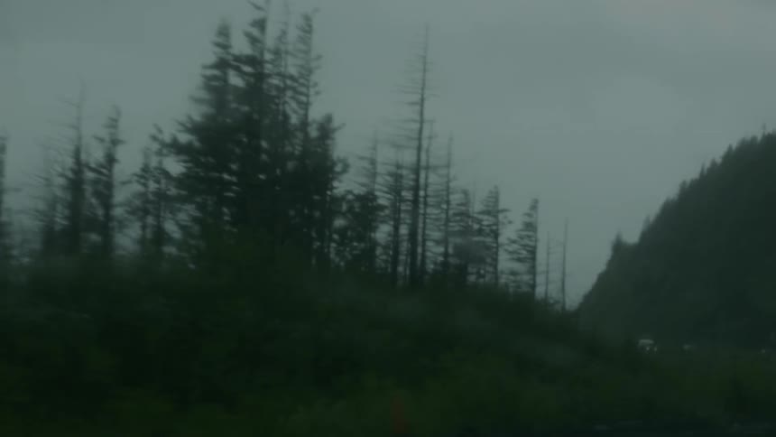 Car drives by ship during a rainstorm
