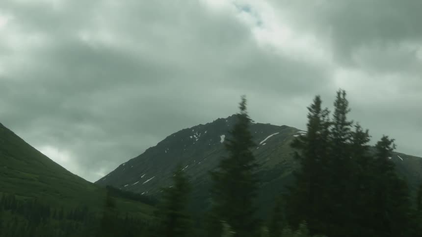 Grey clouds hang above a tall mountain