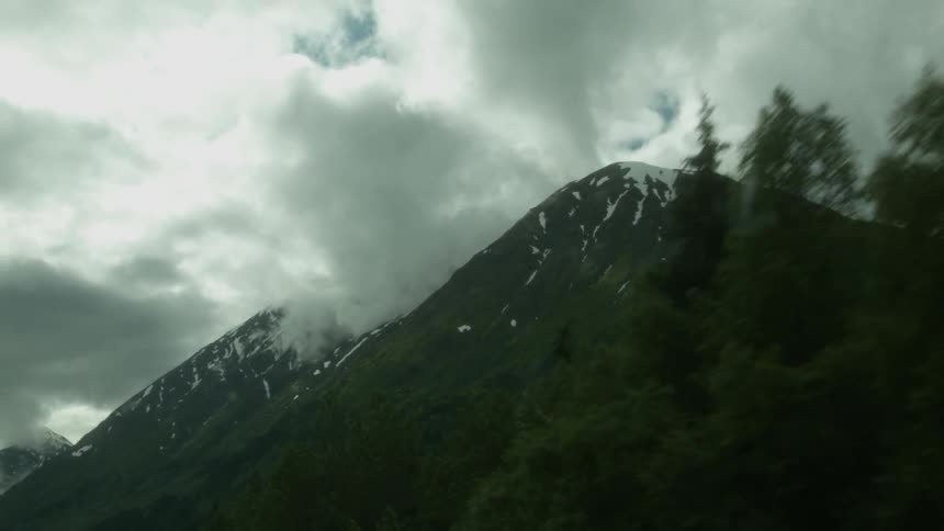 Clouds pass through tall mountains
