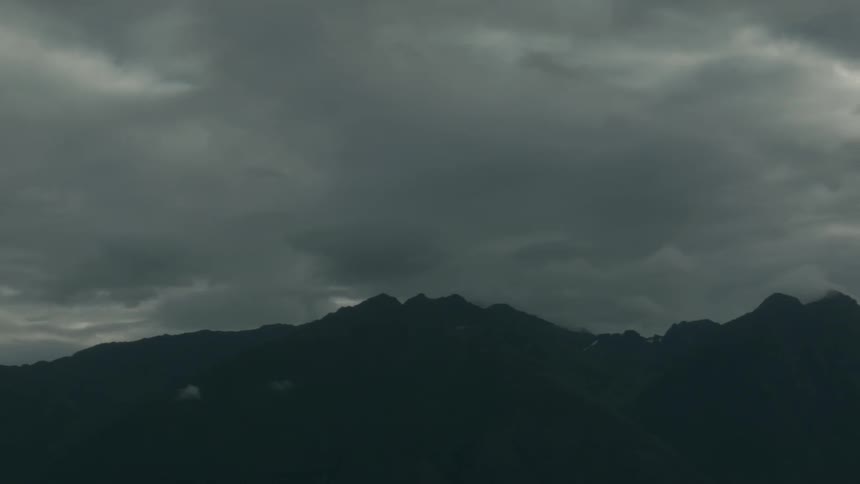 Dark clouds hang above the mountains