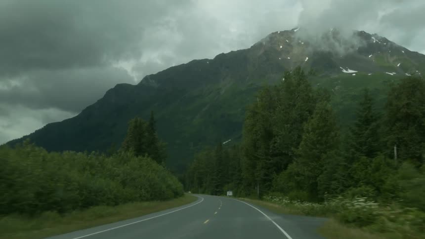 A long road runs around near a mountain