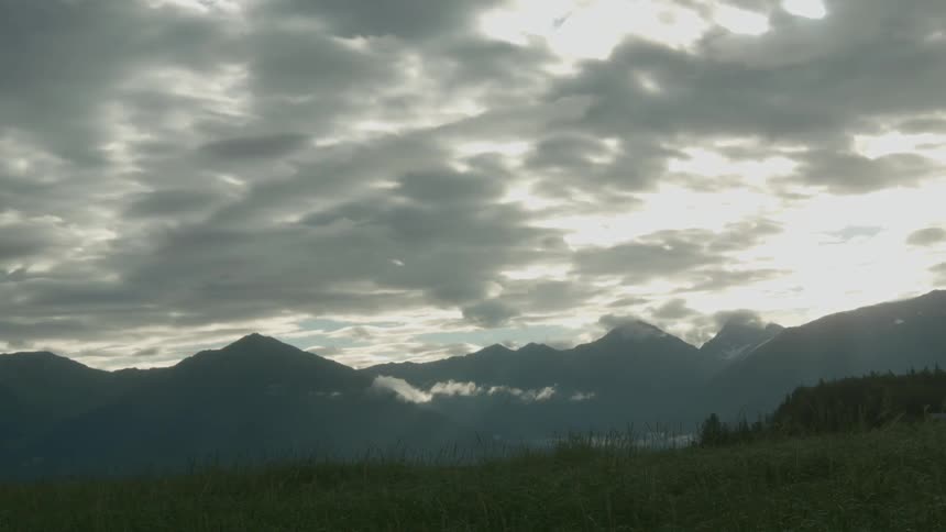 Clouds hover over a mountain range