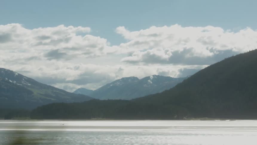 Clouds float over mountains and a lake