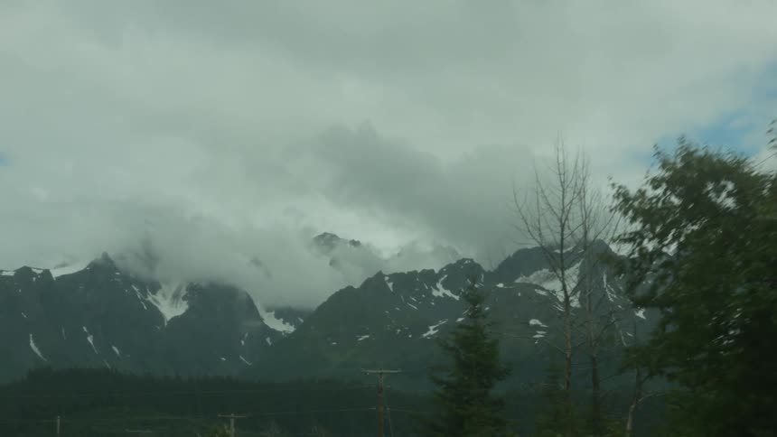 A mountain range is filmed from a car