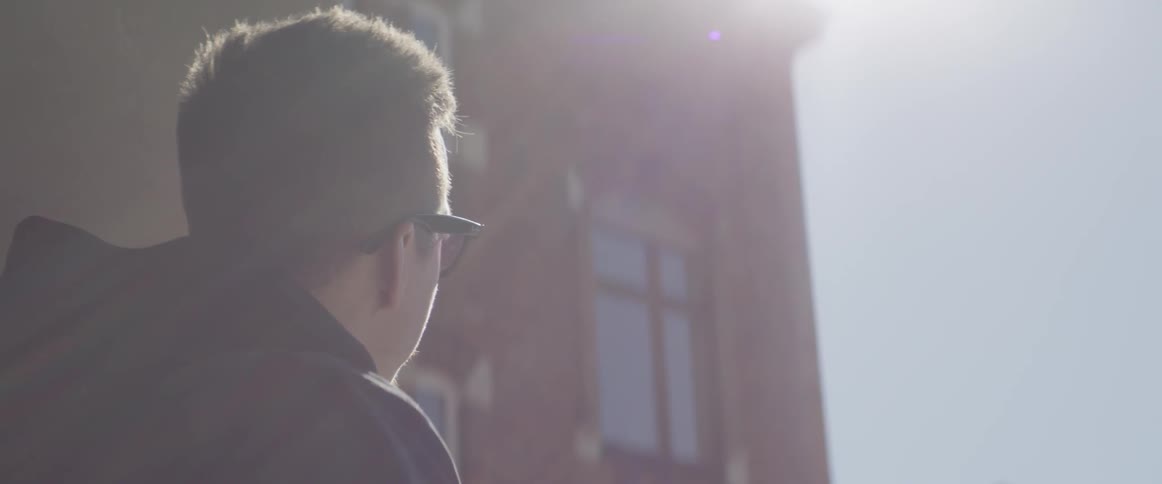 A man glances up at a building during the day