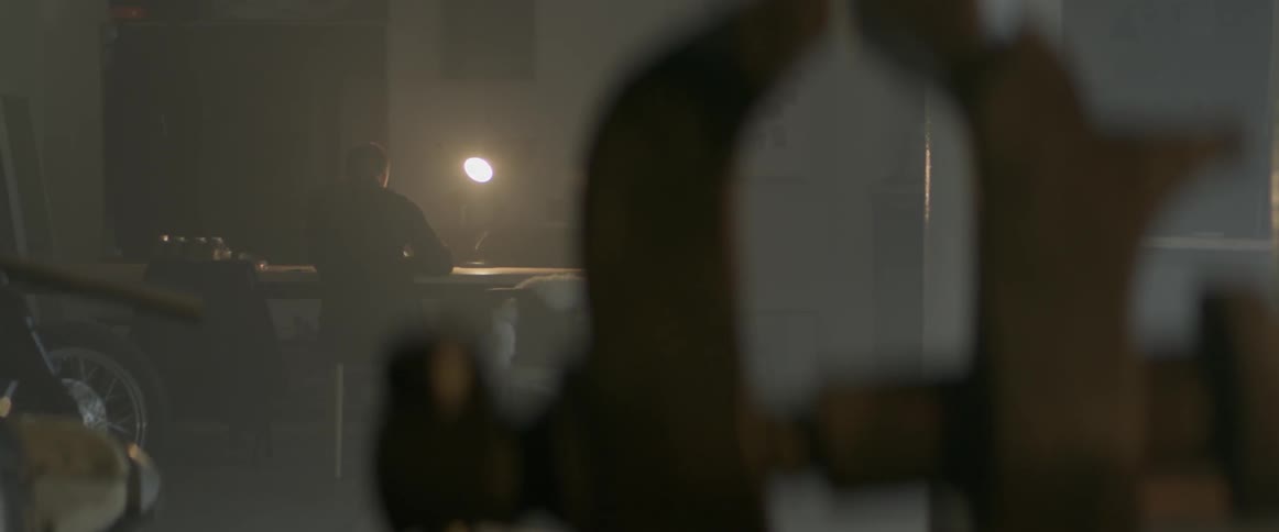 A man is sitting at his work bench