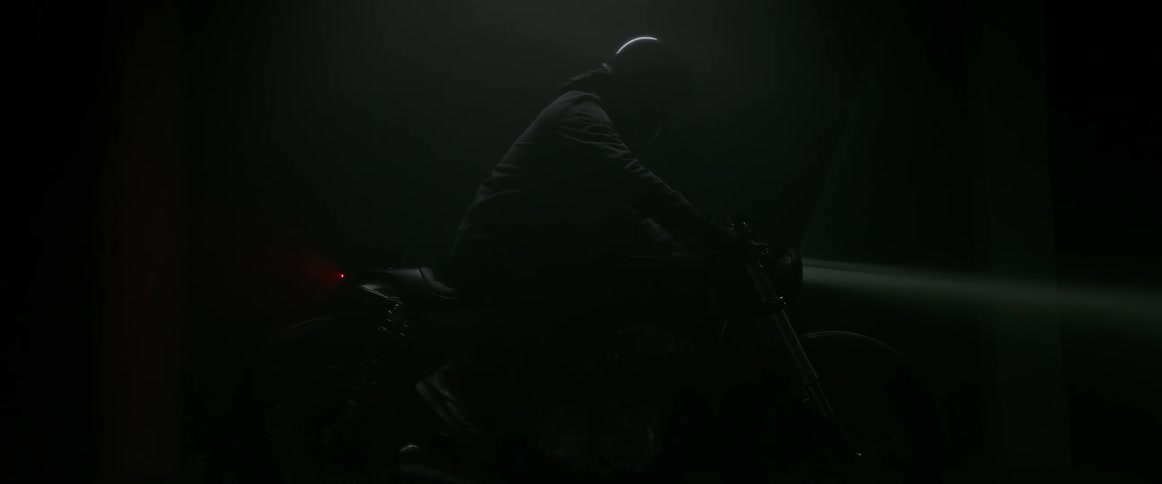A person is on his motorcycle in the dark