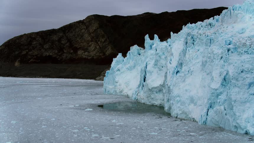 Icebergs tower on the side of water